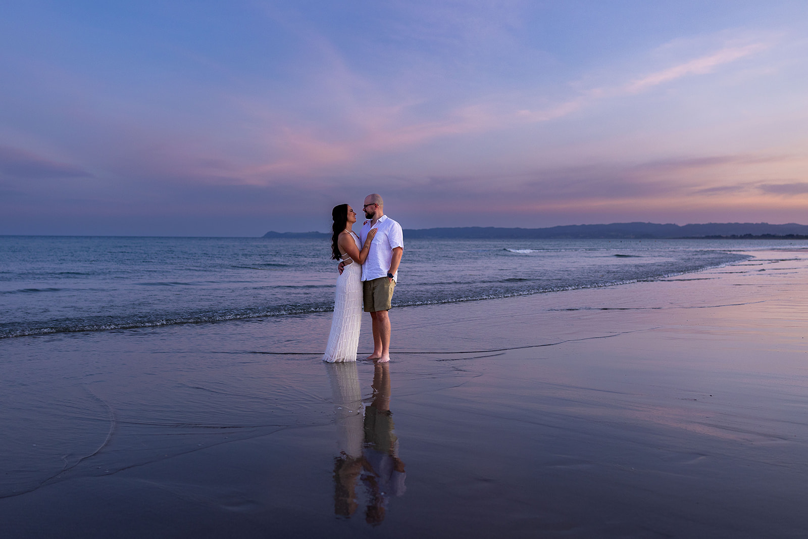 Couple during a sunset engagement photoshoot at Ruakākā Beach, Northland, New Zealand.